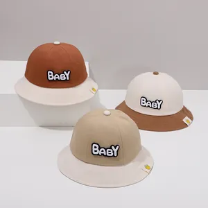 Detail von drei Baby-Fischerhüten aus Baumwolle mit BABY-Stickerei und Blumenetikett