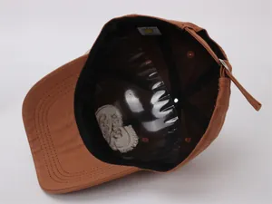 Détail interne d'une casquette marron en coton avec bandeau noir et boucle métallique