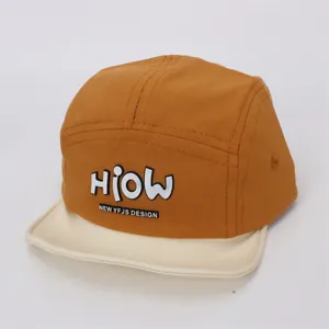 Detail of a 5-panel baby baseball cap with caramel body and off-white brim contrast
