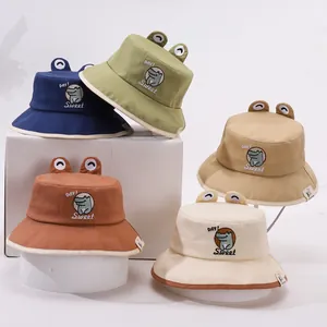 Détail de chapeaux bobs pour enfants en quatre couleurs avec yeux 3D et broderie crocodile