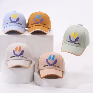 Detail of five assorted children's baseball caps with smiley face on geometric stands
