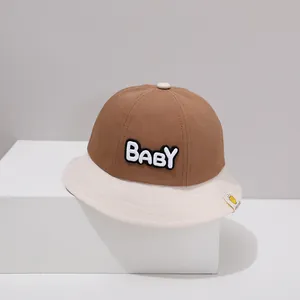 Detail eines farblich abgesetzten Baby-Sonnenhuts mit weißem BABY-Schriftzug Stickerei