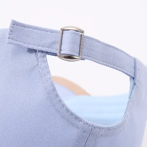 Detail of adjustable metal buckle and light blue cotton strap on the baseball cap back