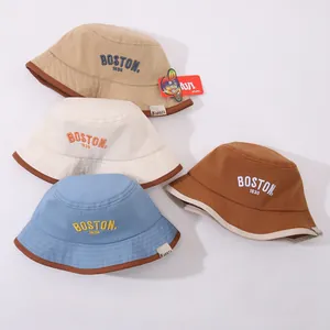 Dettaglio del ricamo BOSTON 1630 su cappelli bucket in tela kaki, beige, blu e marrone