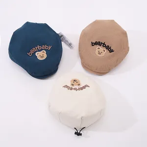 Detailed close-up of baby bear beret hats in navy, khaki, and beige with bear embroidery