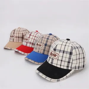 Détail de quatre casquettes de baseball à carreaux avec écussons Quik vintage multicolores