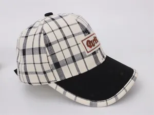 Détail d'une casquette enfant avec tissu à carreaux noir et blanc et broderie QviR