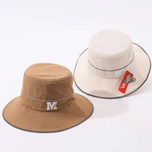 Dettaglio dei cappelli da sole con bordi riflettenti e logo stampato M fashion