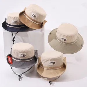 Dettaglio di cappelli bucket a blocchi di colore con lacci regolabili e logo in tessuto