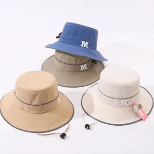 Dettaglio di cappelli da sole per bambini con logo M, strisce riflettenti e cinturino regolabile