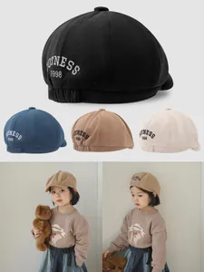 Detail view of cotton kids beret hats with 1998 embroidery in four assorted colors