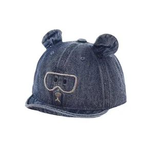 Casquette en jean pour bébé avec oreilles d'ours et broderie sur fond blanc