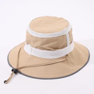 Dettaglio del cappello da sole kaki con nastro bianco decorativo e cordino regolabile