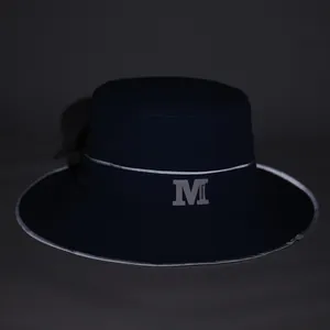 Dettaglio del cappello da sole blu scuro con logo M riflettente e testo fashion