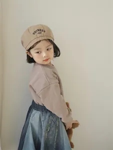 Close-up of kids light brown beret hat featuring black BOTNESS 1998 embroidery detail