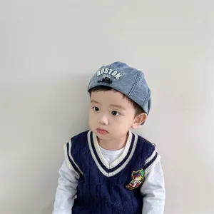 Béret enfant en denim avec broderie BOSTON sur un fond de couleur neutre