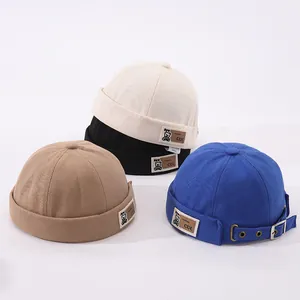 Détail de la boucle métallique réglable et de la sangle en cuir sur les bonnets miki