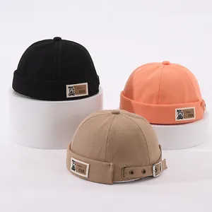 Détails de bonnets Miki en coton coloré avec boucles en métal et écusson lettré