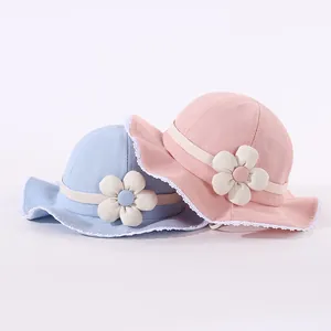 Detailed close-up of baby sun hats with delicate lace trim and large floral accents