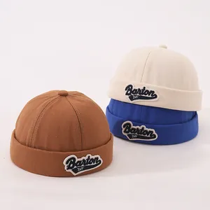 Close-up of cotton docker hats in brown, beige and blue with Barton 3VF embroidery detail