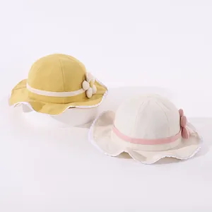 Detailed view of baby sun hats featuring lace edges and 3D floral accents in yellow and beige