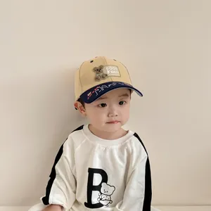 Close-up of color-block baby baseball cap featuring cartoon bear patch and embroidery
