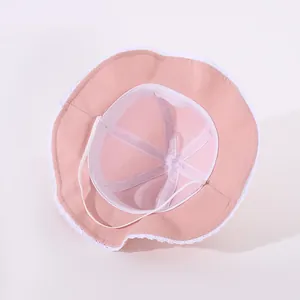 Detailed interior of pink baby sun hat showing lace trim and elastic windproof strap