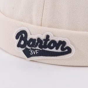Beige cotton brimless docker hat for kids with Barton embroidered patch and textured fabric