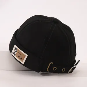 Détail de la sangle réglable et boucle en métal sur ce bonnet docker noir à écusson