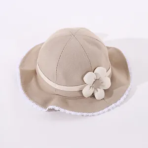 Close-up of baby sun hat with delicate white lace trim and 3D fabric flower detail
