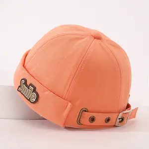 Detail der korallenorangen Kinder-Vermieterkappe mit Smile-Patch und Metallschnalle