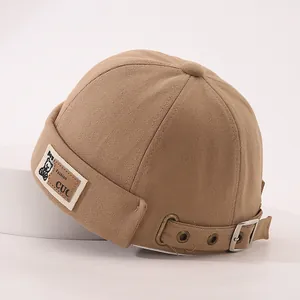 Détail du bonnet docker kaki avec écusson ours et boucle métallique ajustable