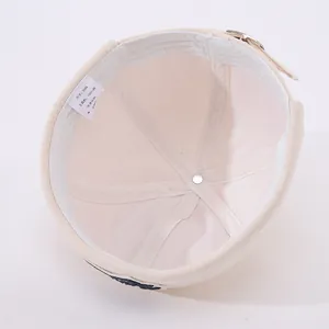 Detailed interior of beige cotton skull cap showing sweatband and washing label