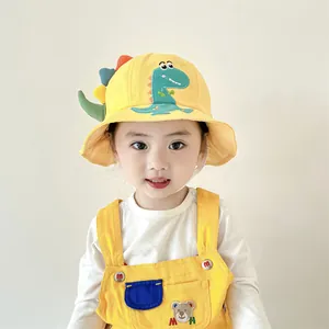 Detailed view of yellow cotton kids bucket hat with 3D cartoon dinosaur spikes