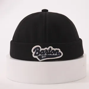 Detail of black cotton miki hat featuring blue and white Barton 3VF embroidery patches