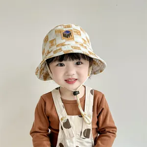 Detalle de gorro de pescador infantil a cuadros amarillos con parche de cuero y cordón