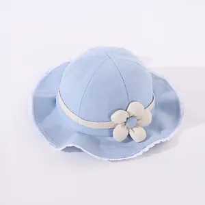 Close-up of light blue baby sun hat featuring white lace trim and 3D floral detail