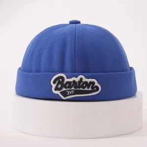 Close-up of royal blue cotton brimless cap with Barton embroidered patch and folded edge