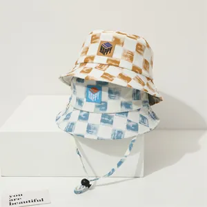 Detalle de sombreros de pescador a cuadros para niños con parche HAPPY y cordón ajustable