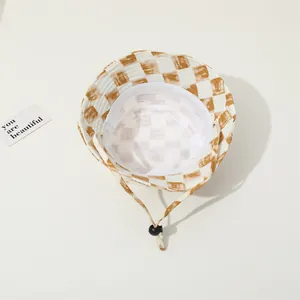 Detalle de gorro de pescador a cuadros con cordón ajustable beige y hebilla negra