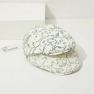 Béret pour enfants crème avec imprimés dinosaures bleu marine et motifs de cœurs