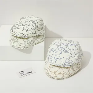 Détail de bérets en coton pour enfants avec imprimés dinosaures sur tissu beige doux