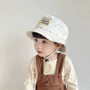 Detail of baby sun hat with LOVE YOU patch, dinosaur print and adjustable chin strap
