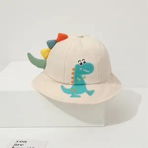 Detailed embroidery of a cartoon dinosaur on a beige cotton bucket hat for children