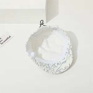 Détail d'un béret pour enfant en coton avec motif dinosaure et boucle de réglage pratique