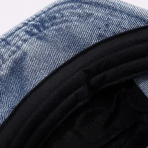 Detailed close-up of blue denim baseball cap fabric texture and fine inner stitching