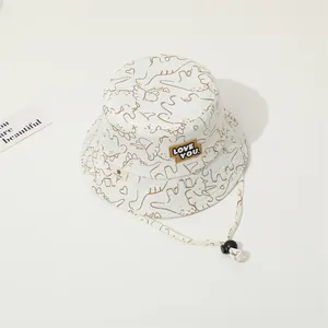 Detail of baby sun hat featuring dinosaur prints, LOVE YOU patch and adjustable chin strap