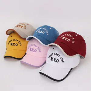 Detail of embroidered NYC lettering and vibrant multi-color kids' baseball caps