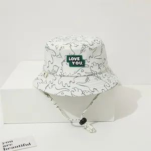 Detail of white kids sun hat with black dinosaur prints and LOVE YOU patch