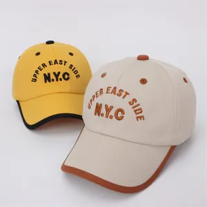 Kids NYC baseball caps in yellow and beige colors featuring Upper East Side embroidery